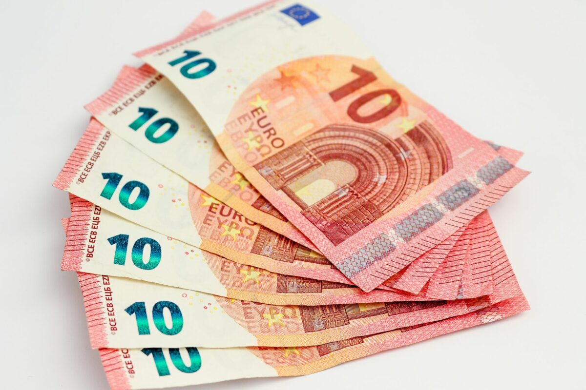 Close-up of a fan of 10 euro banknotes on a clean white background, showcasing European currency. (photo Pexels)